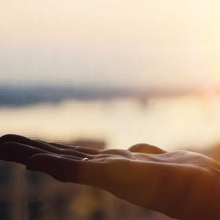 Open palm held toward the sunset