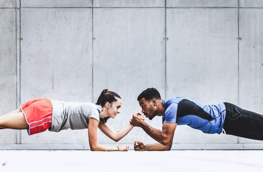 Two people holding a plank and shaking hands