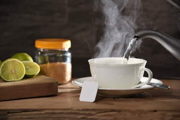 Steaming cup of hot water with a tea bag