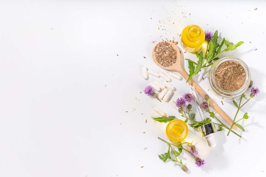 Herbal supplements, oils and botanicals on a wooden spoon